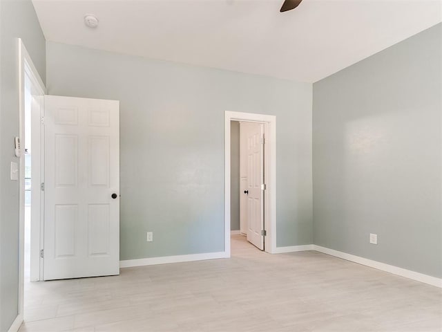 unfurnished bedroom featuring a ceiling fan, light wood-style flooring, and baseboards