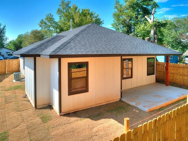 view of outdoor structure featuring central AC unit and a fenced backyard