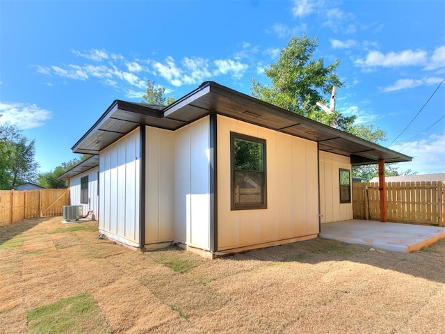 view of property exterior with a patio, central AC, and fence