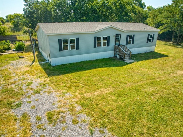 manufactured / mobile home featuring driveway and a front yard