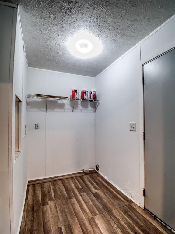 washroom featuring laundry area, a textured ceiling, and dark wood-style flooring