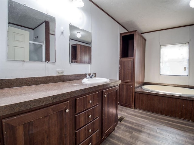 bathroom featuring ornamental molding, a shower with shower door, vanity, wood finished floors, and a bath