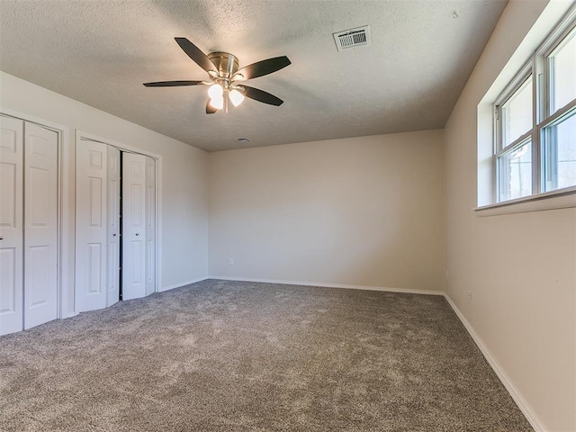 unfurnished bedroom with baseboards, visible vents, a textured ceiling, and carpet flooring