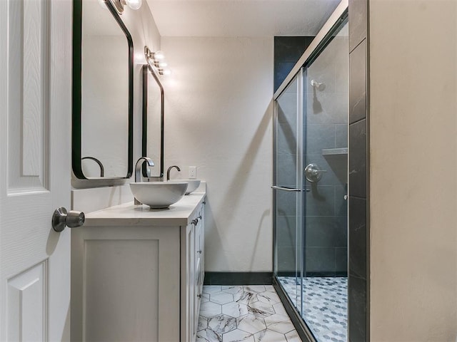 full bathroom with baseboards, a shower stall, and vanity