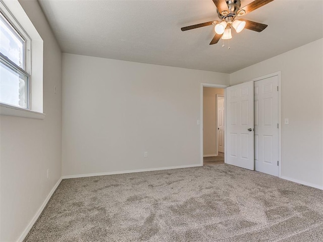 unfurnished bedroom featuring ceiling fan, carpet flooring, and baseboards