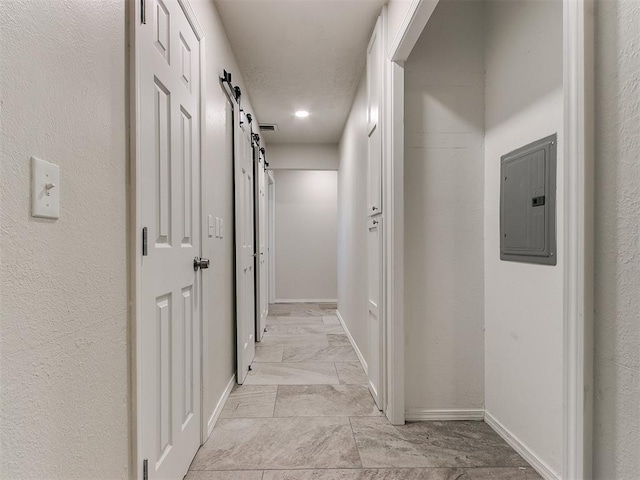 hallway with electric panel, baseboards, and a barn door