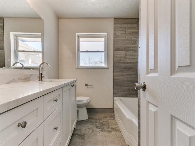 full bathroom featuring baseboards, a healthy amount of sunlight, vanity, and toilet