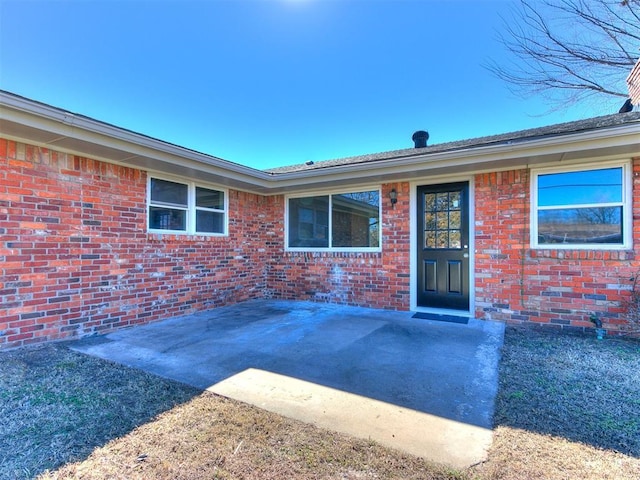 view of exterior entry with brick siding