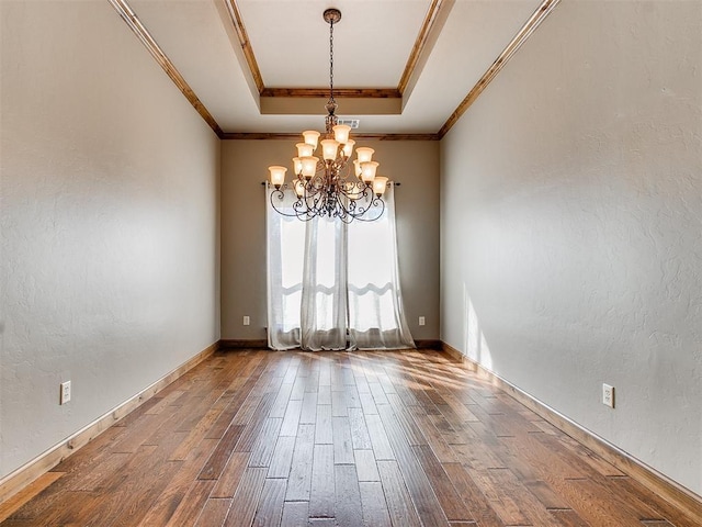 unfurnished room with crown molding, a tray ceiling, dark wood-type flooring, and a textured wall