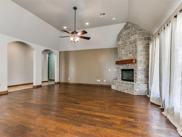 unfurnished living room with hardwood / wood-style flooring, ceiling fan, baseboards, and a stone fireplace