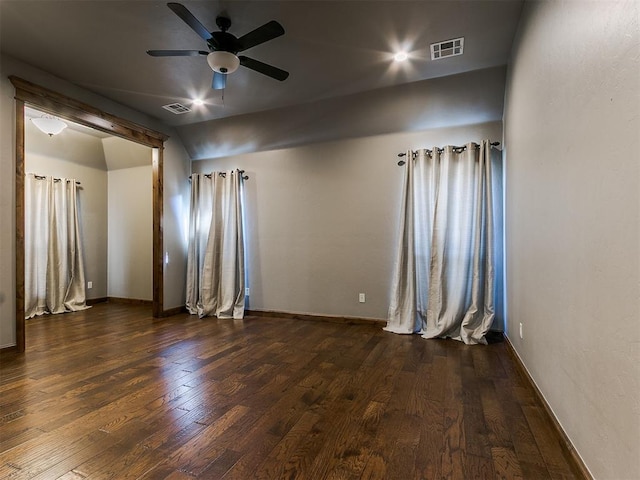 spare room featuring lofted ceiling, dark wood finished floors, visible vents, and baseboards