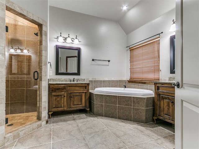 bathroom featuring lofted ceiling, a garden tub, vanity, a shower stall, and tile patterned floors