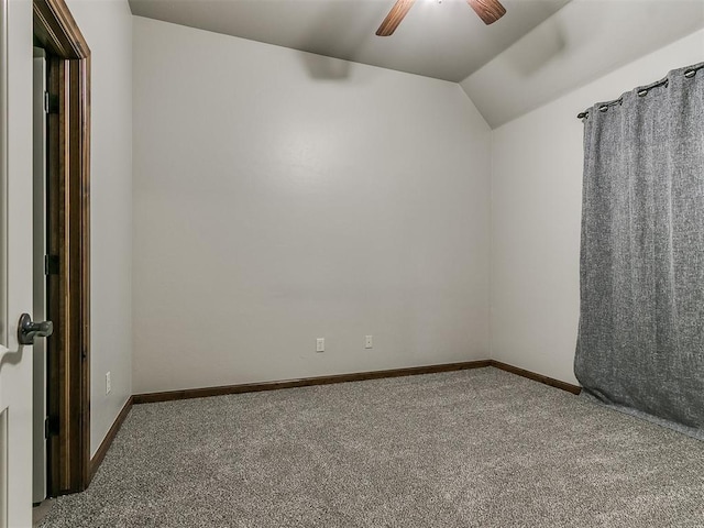 spare room with carpet, baseboards, vaulted ceiling, and a ceiling fan