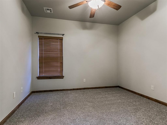 spare room with carpet floors, ceiling fan, visible vents, and baseboards