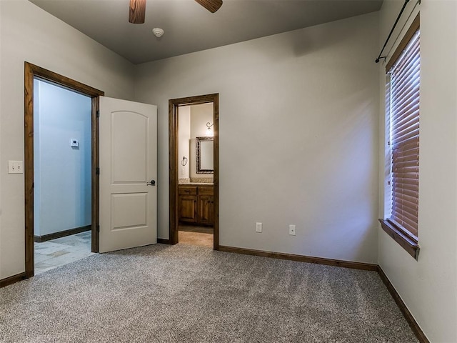 unfurnished bedroom with a ceiling fan, light carpet, baseboards, and ensuite bathroom