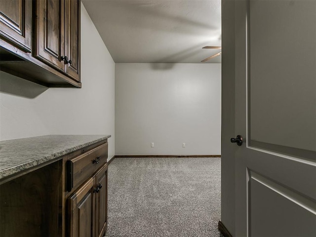 empty room with ceiling fan, baseboards, and carpet flooring