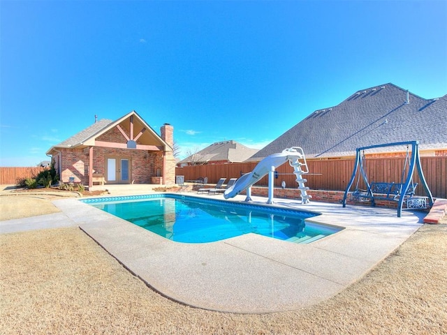 view of swimming pool with a patio, a water slide, a fenced backyard, french doors, and a fenced in pool