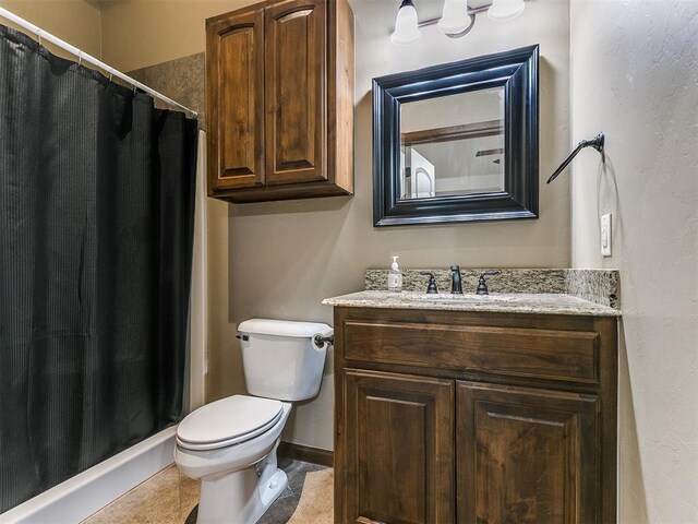 bathroom with baseboards, a shower with shower curtain, toilet, tile patterned floors, and vanity