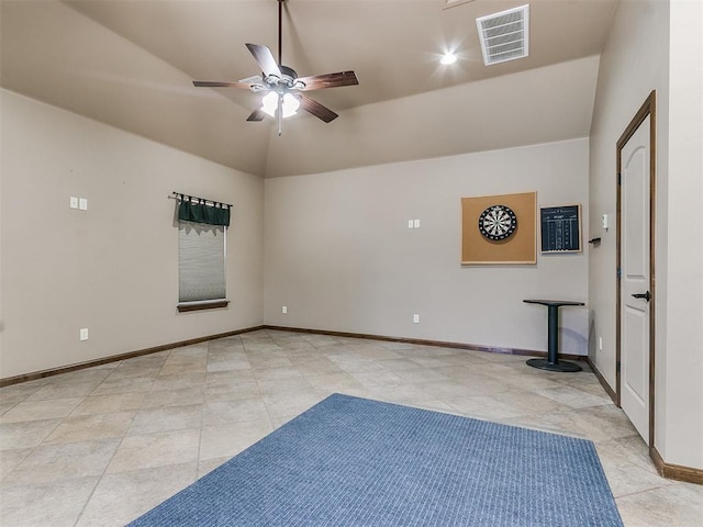 spare room featuring ceiling fan, light tile patterned flooring, visible vents, baseboards, and vaulted ceiling