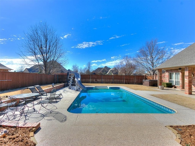 view of swimming pool featuring a water slide, a patio area, a fenced backyard, and a fenced in pool