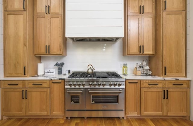 kitchen featuring light wood-style floors, double oven range, custom exhaust hood, and light countertops