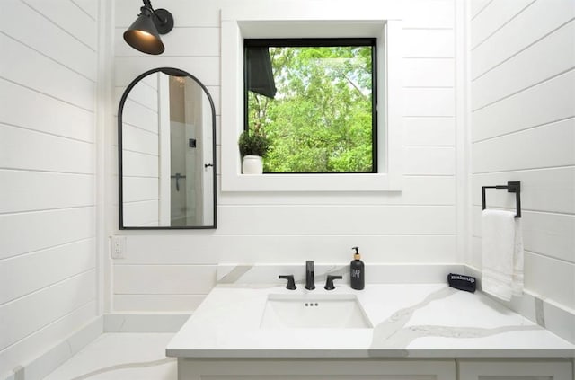 bathroom with vanity and wooden walls