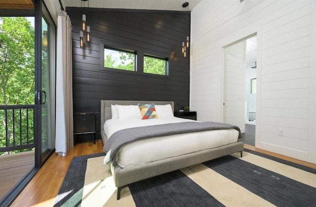 bedroom featuring wood walls and wood finished floors