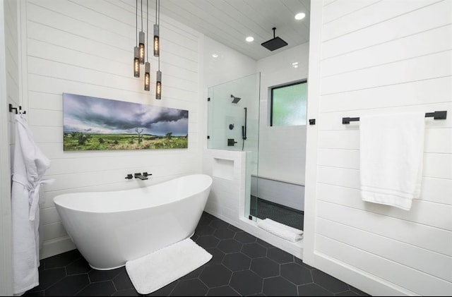 full bath featuring tile patterned flooring, a walk in shower, a freestanding bath, and recessed lighting