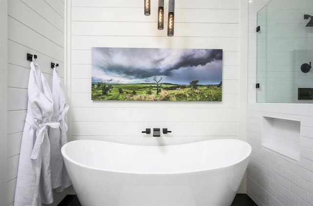 full bathroom featuring a tile shower and a freestanding bath