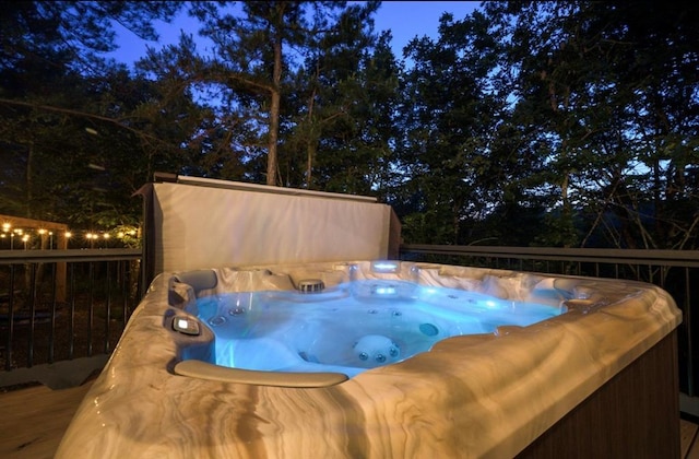 view of pool with fence and a hot tub