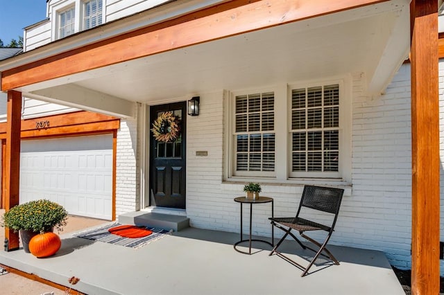 property entrance with a garage and brick siding