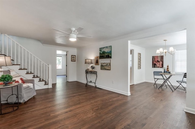 foyer entrance featuring baseboards, dark wood-style floors, ornamental molding, stairs, and ceiling fan with notable chandelier