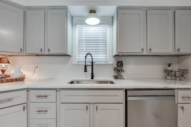 kitchen featuring dishwasher, light countertops, and a sink