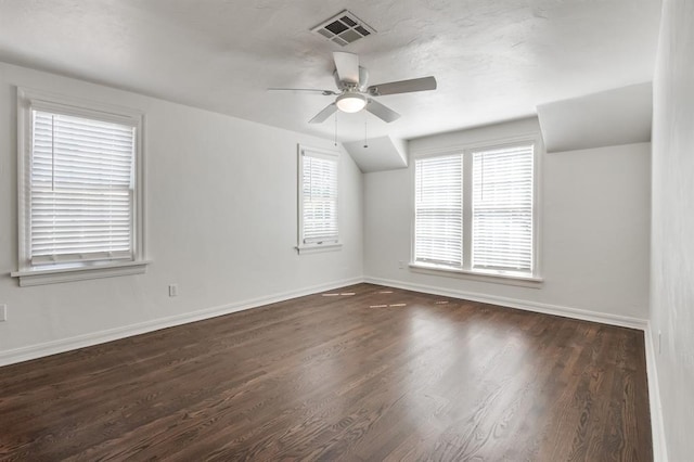 additional living space with a ceiling fan, baseboards, visible vents, and dark wood-type flooring