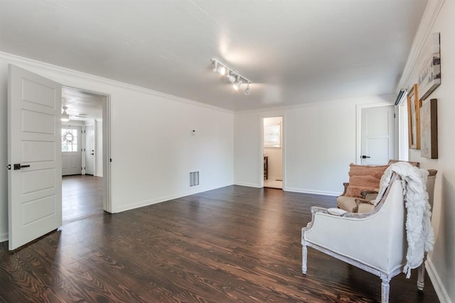 sitting room with crown molding, visible vents, baseboards, dark wood-style floors, and track lighting