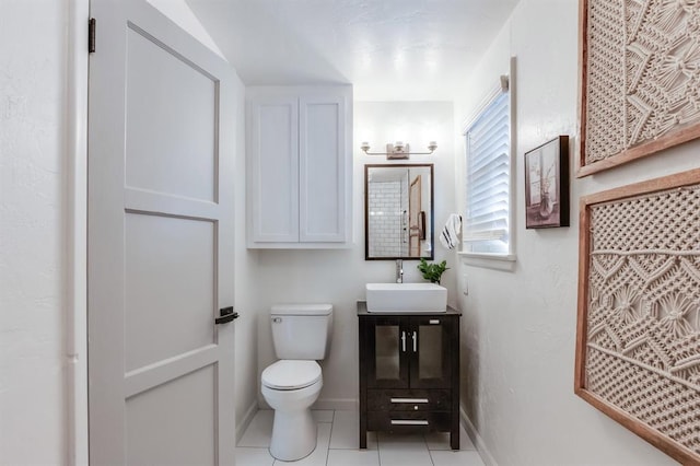 half bath featuring baseboards, vanity, toilet, and tile patterned floors