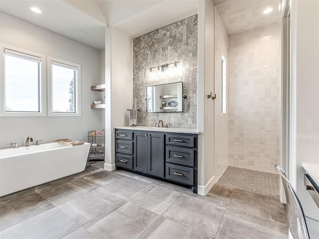 full bath featuring baseboards, a tile shower, vanity, a freestanding tub, and recessed lighting