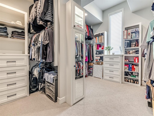 walk in closet featuring light colored carpet