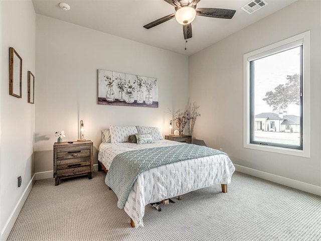 bedroom featuring baseboards, visible vents, and light colored carpet