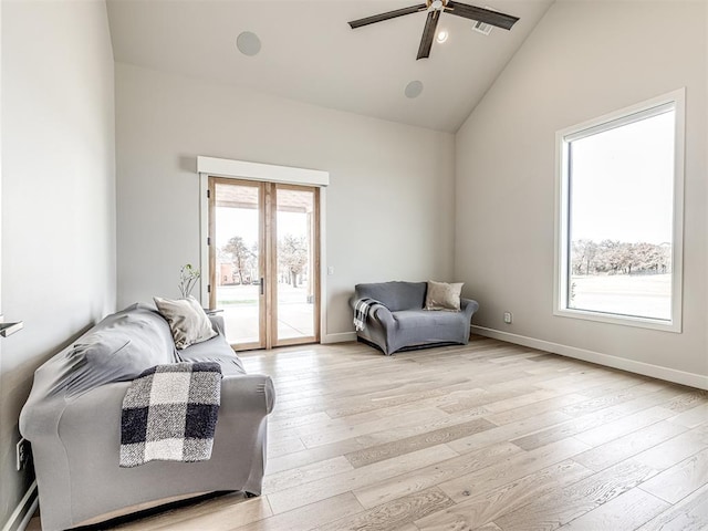 interior space with baseboards, a ceiling fan, lofted ceiling, light wood-style flooring, and french doors