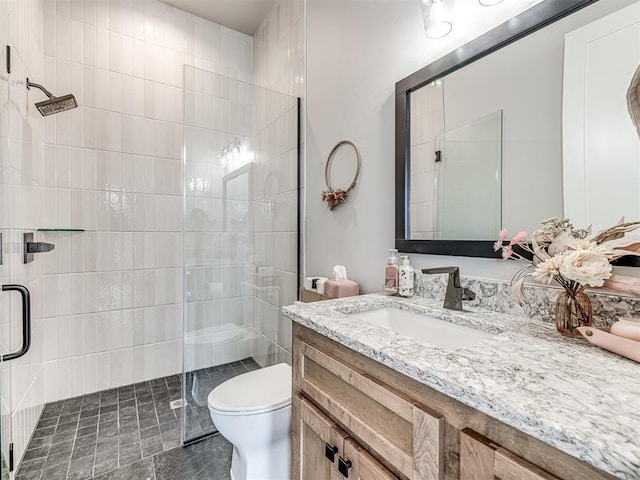 bathroom with vanity, a shower stall, and toilet