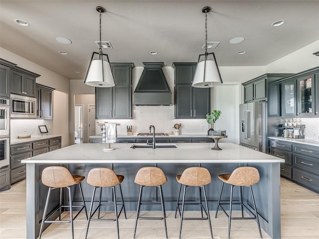 4716 Moulin Rd, Edmond, OK 73034 - kitchen with a sink, a kitchen breakfast bar, premium range hood, stainless steel appliances, and a spacious island