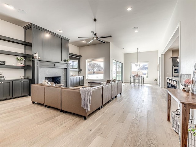 4716 Moulin Rd, Edmond, OK 73034 - living room featuring light wood finished floors, a fireplace, ceiling fan with notable chandelier, recessed lighting, and baseboards
