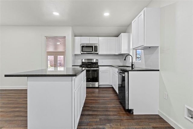 kitchen with stainless steel appliances, dark wood-type flooring, a sink, and white cabinetry