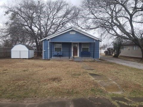 bungalow-style home featuring an outbuilding, a storage shed, a porch, and a front yard