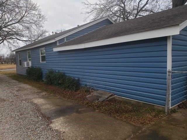 view of side of home featuring roof with shingles