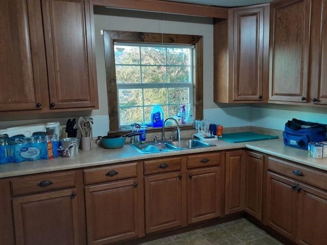 kitchen with light countertops, a sink, and brown cabinets