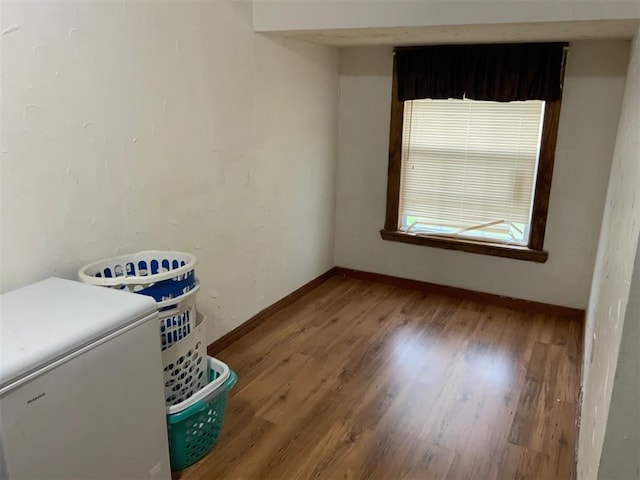 interior space featuring baseboards and wood finished floors