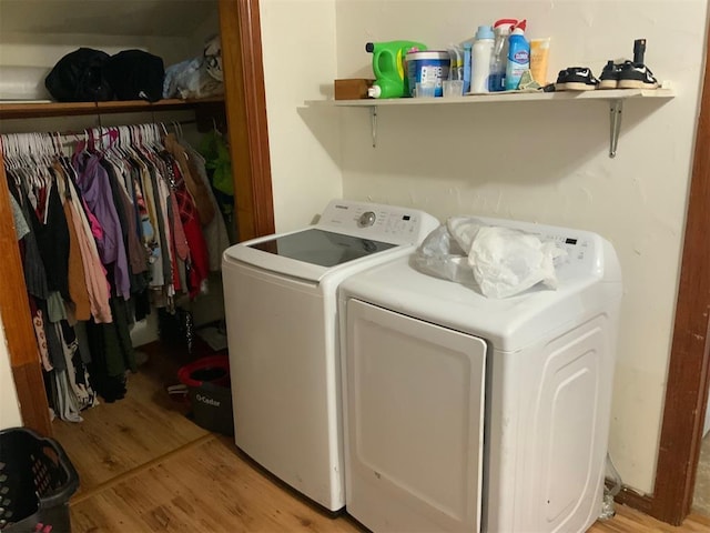 washroom featuring laundry area, light wood-style flooring, and washing machine and clothes dryer