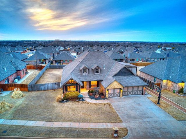 view of front of house featuring a garage, driveway, a residential view, and fence